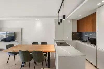 a kitchen and dining room with a wooden table and chairs at REF 2006 - Cannes Croisette - Luxurious apartment with sea view for rent in Cannes
