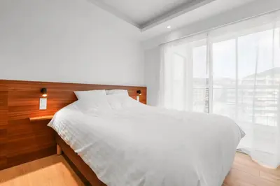 a white bed in a bedroom with a large window at REF 2006 - Cannes Croisette - Luxurious apartment with sea view for rent in Cannes