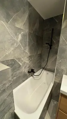 a white bath tub in a bathroom with marble walls at Renovated & cozy apartment in Cannes