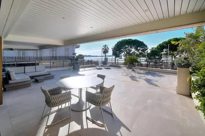 a patio with a table and chairs and a view of the ocean at REF 1429 - Cannes Croisette - Sea view apartment for rent in Cannes