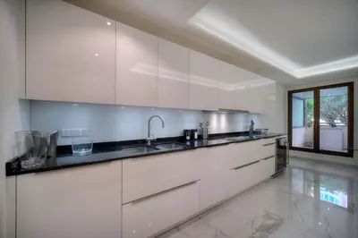 a kitchen with white cabinets and a sink at REF 1429 - Cannes Croisette - Sea view apartment for rent in Cannes