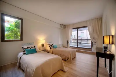a hotel room with two beds and a window at REF 1429 - Cannes Croisette - Sea view apartment for rent in Cannes