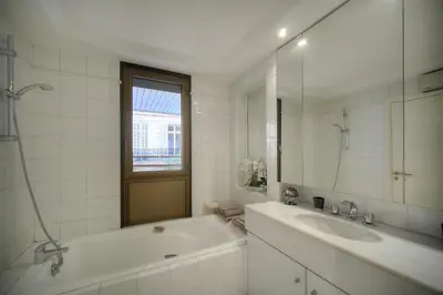 a bathroom with a tub and a sink and a mirror at REF 1429 - Cannes Croisette - Sea view apartment for rent in Cannes