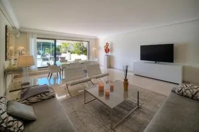 a living room with a couch and a tv at REF 1429 - Cannes Croisette - Sea view apartment for rent in Cannes