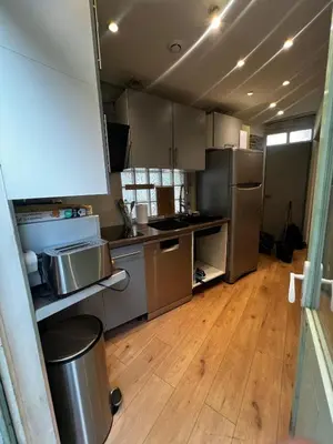 a kitchen with stainless steel appliances and wooden floors at Townhouse with garden in Cannes