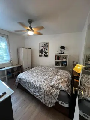 a bedroom with a bed and a ceiling fan at Townhouse with garden in Cannes