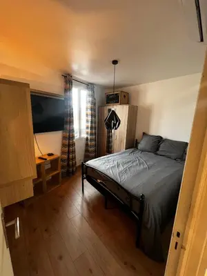 a bedroom with a bed and a desk and a window at Townhouse with garden in Cannes