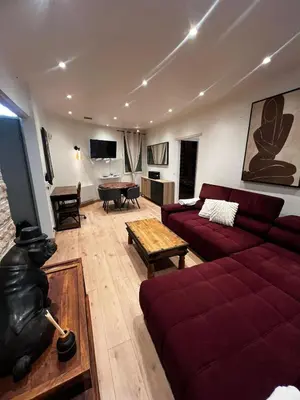 a living room with a red couch and a table at Townhouse with garden in Cannes