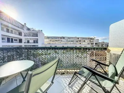 a balcony with chairs and a table and some buildings at INTUITION Studio avec terrasse 3min Croisette in Cannes