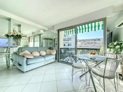 a living room with a couch and a table at INTUITION Studio avec terrasse 3min Croisette in Cannes