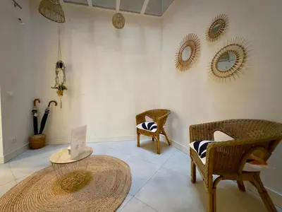 a room with wicker chairs and a table and mirrors at Le Kallisté By SCLS Locations in Cannes