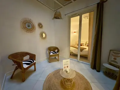a room with a table and chairs and a bedroom at Le Kallisté By SCLS Locations in Cannes