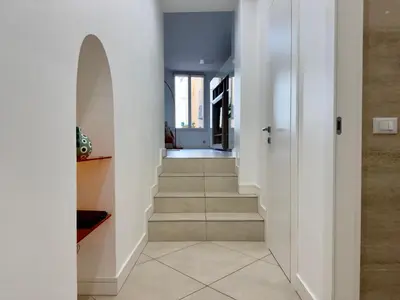 a hallway with white walls and carpeted floors and stairs at Le Kallisté By SCLS Locations in Cannes