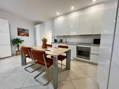 a kitchen with a wooden table and chairs at Le Kallisté By SCLS Locations in Cannes