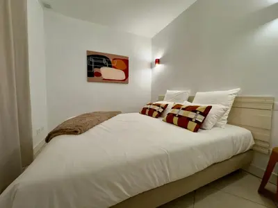 a bedroom with a bed with white sheets and pillows at Le Kallisté By SCLS Locations in Cannes