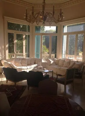 a living room with a large white couch and windows at 170 m2 with terrace near Croisette in Cannes