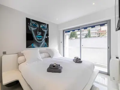 a bedroom with a white bed with a large window at Beautiful Apartment with Balcony 1BR 2P - Cannes in Cannes
