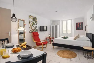 a bedroom with a bed and a table with a dining room at Studio plage et palais Cannes meynadier 1 in Cannes