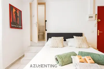 a bedroom with a white bed with two pillows at Studio plage et palais Cannes meynadier 1 in Cannes