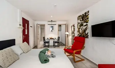 a living room with a couch and a red chair at Studio plage et palais Cannes meynadier 1 in Cannes