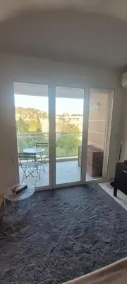 a living room with a large glass door with a table at Centre Cannes Bristol in Cannes