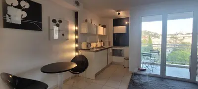 a kitchen with a table and chairs and a window at Centre Cannes Bristol in Cannes