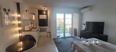 a room with a kitchen with a table and a television at Centre Cannes Bristol in Cannes