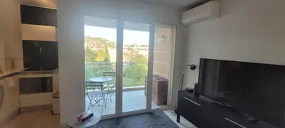 a living room with a television and a balcony at Centre Cannes Bristol in Cannes