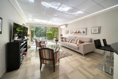 a living room with a couch and a table and chairs at REF 1413 - Cannes Center Appartment for rent in Cannes