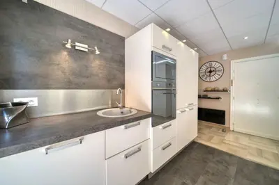 a kitchen with white cabinets and a sink at REF 1413 - Cannes Center Appartment for rent in Cannes
