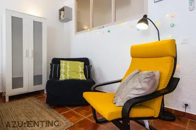 a yellow chair in a living room with a suitcase at Cozy Studio Cannes 2 min Croisette & Palais 3 in Cannes