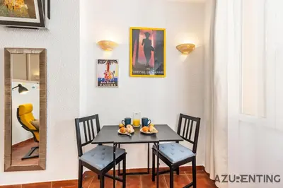 a dining room table with two chairs and a mirror at Cozy Studio Cannes 2 min Croisette & Palais 3 in Cannes
