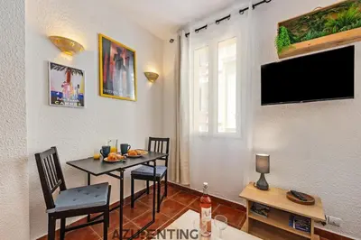 a dining room with a table and a tv on the wall at Cozy Studio Cannes 2 min Croisette & Palais 3 in Cannes