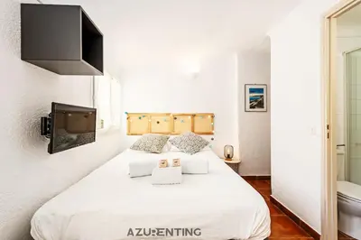 a bedroom with a large white bed and a toilet at Cozy Studio Cannes Plage Croisette 4 in Cannes