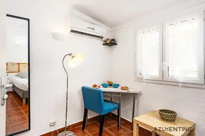 a small room with a table and a blue chair at Cozy Studio Cannes Plage Croisette 4 in Cannes