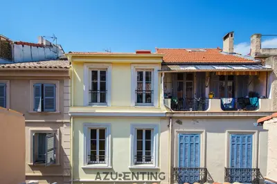 a white building with blue shutters on it at Cozy Studio Cannes Plage Croisette 4 in Cannes