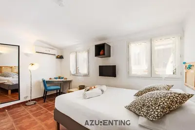 a bedroom with a large white bed and a desk at Cozy Studio Cannes Plage Croisette 4 in Cannes