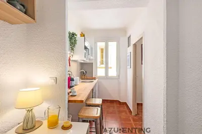 a kitchen with a counter and a table with a lamp at Studio lumineux au cœur de Cannes 2 in Cannes