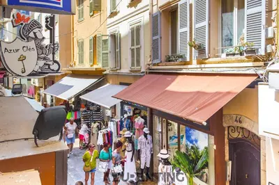 a group of people walking down a street with shops at Studio lumineux au cœur de Cannes 2 in Cannes