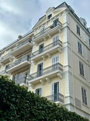 a bedroom with a large white bed and a chair at Legend of Beausite in Cannes