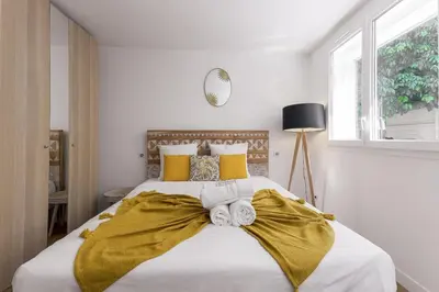 a bedroom with a large bed with yellow pillows at Good Vibes - 10mn from harbor, 5mn from Palais and train station, central, AC, comfy in Cannes