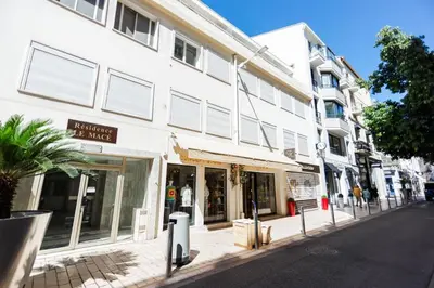 a white building with a store on a street at Good Vibes - 10mn from harbor, 5mn from Palais and train station, central, AC, comfy in Cannes