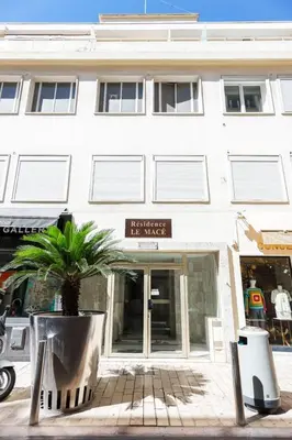a white building with a palm tree in front of it at Good Vibes - 10mn from harbor, 5mn from Palais and train station, central, AC, comfy in Cannes