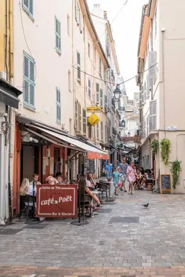 a street with a group of people sitting at tables at NEW Le Backstage Croisette et Plages à 5 min Cannes Lifestyle Central Stay OFFRE SPECIALE in Cannes