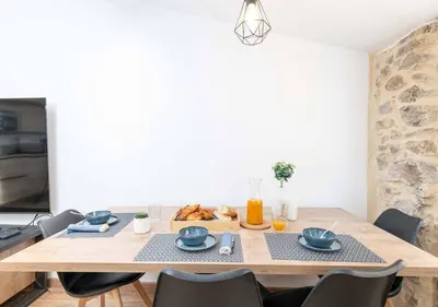 a dining room with a wooden table and chairs at NEW Le Backstage Croisette et Plages à 5 min Cannes Lifestyle Central Stay OFFRE SPECIALE in Cannes