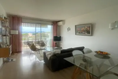 a living room with a couch and a glass table at Escape in Cannes sea view and shared pool! in Cannes