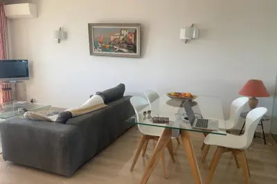 a living room with a couch and a glass table at Escape in Cannes sea view and shared pool! in Cannes