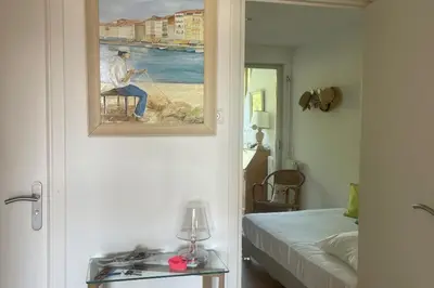 a room with a painting of a man sitting on a chair at Escape in Cannes sea view and shared pool! in Cannes