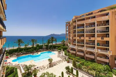 an aerial view of a hotel with a swimming pool and the ocean at La Palme d'Azur - Cannes in Cannes
