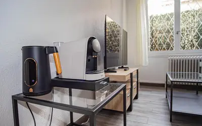 a coffee maker on a glass table in a living room at Charmant 2p proche des plages, appartement Céladon in Cannes